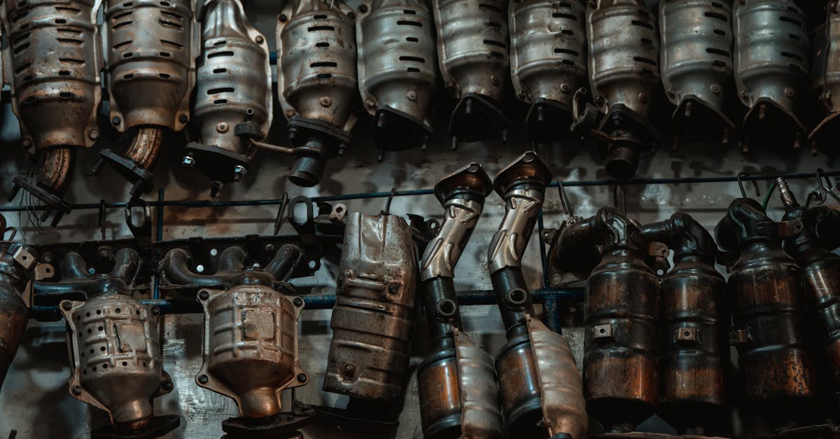 Stack of used catalytic converters in workshop — P0420 catalyst efficiency below threshold diagnosis