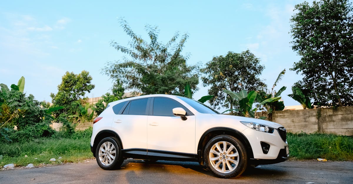 White SUV on tree-lined road — C0561 StabiliTrak code and ground-strap fix for Chevrolet Traverse