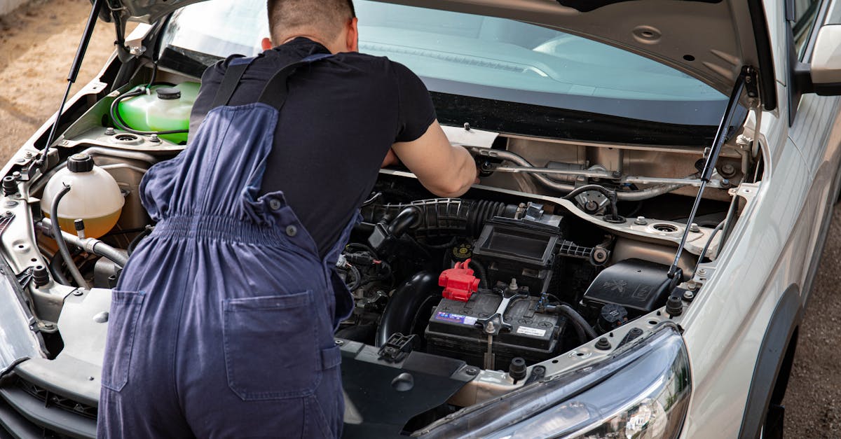 Mechanic inspecting car engine bay — P0171 system too lean diagnosis vacuum leak MAF sensor