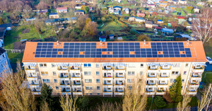 Stambena zgrada sa solarnim panelima na krovu — balkonski solarni sistem za stan