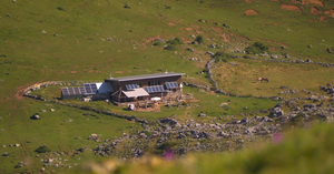 Vikendica sa solarnim panelima na vrhu brda — autonomni off-grid solarni sistem